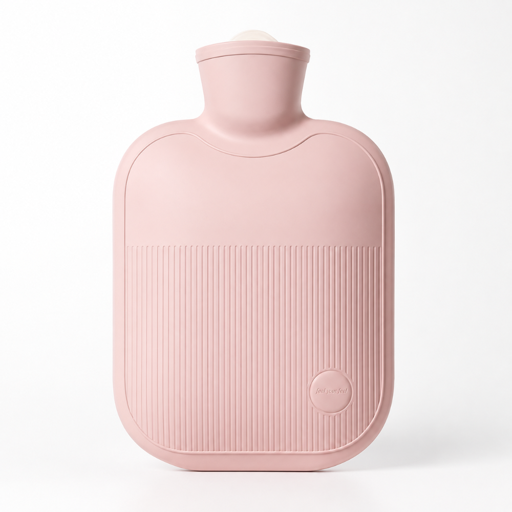 A dusty pink silicone hot water bottle with a ribbed front panel and a small circular logo, photographed on a clean white background.